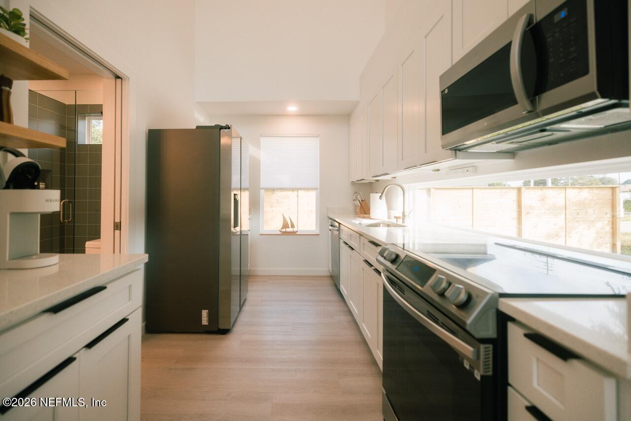 3318 Lewis Speedway St. Augustine, FL 32084 - Photo 6 of 23 a kitchen with a sink a refrigerator and cabinets