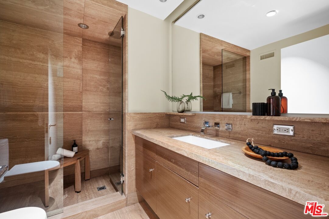 11496 Orum Road Los Angeles, CA 90049 - Photo 13 of 30 a bathroom with a granite countertop sink a toilet and a mirror