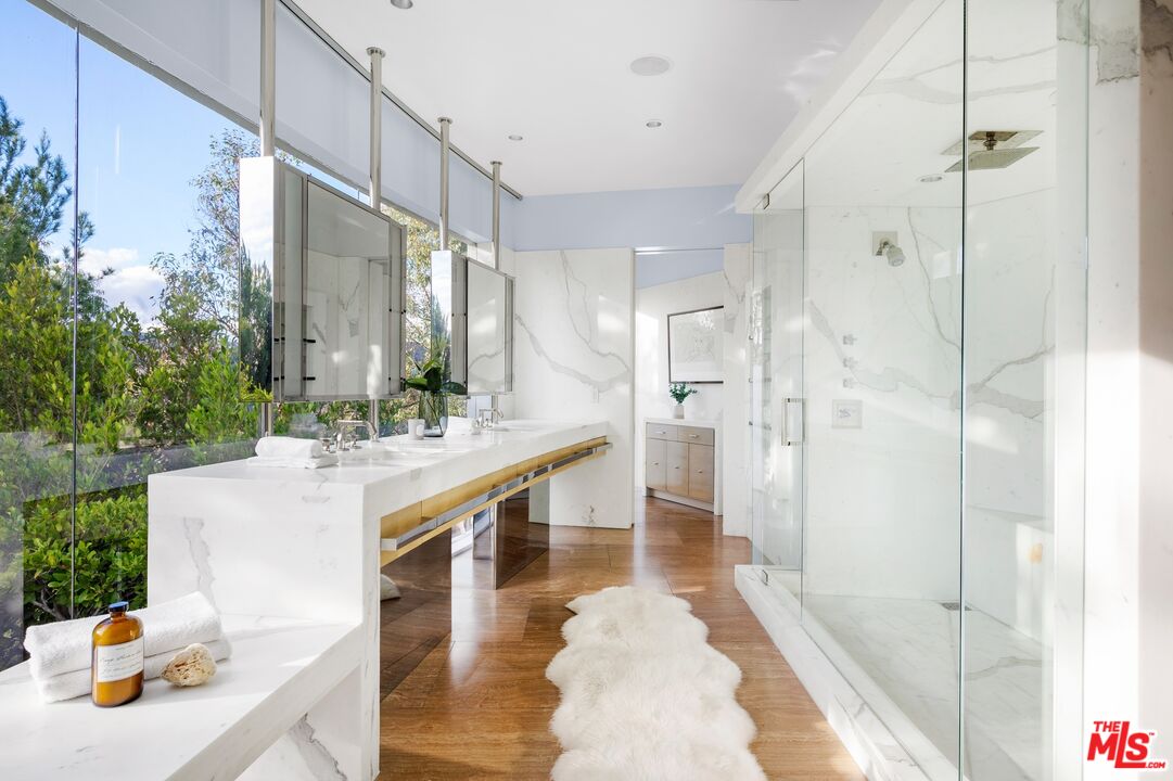 11496 Orum Road Los Angeles, CA 90049 - Photo 25 of 30 a large white bathroom with a sink a mirror and shower