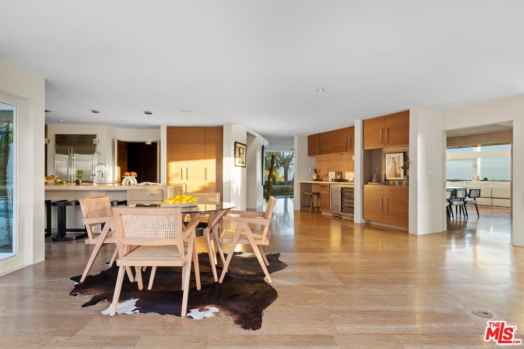 11496 Orum Road Los Angeles, CA 90049 - Photo 10 of 30 a dining hall with stainless steel appliances a dining table and chairs with wooden floor
