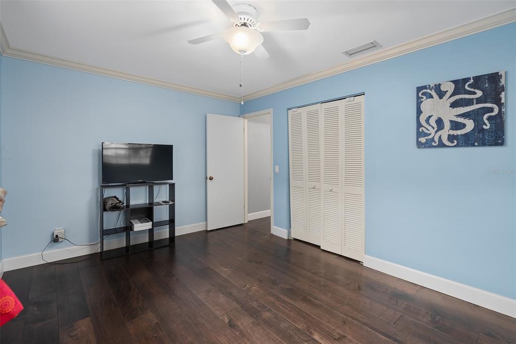 744 Cornwall Road Winter Park, FL 32792 - Photo 12 of 57 a view of an empty room with wooden floor and a ceiling fan