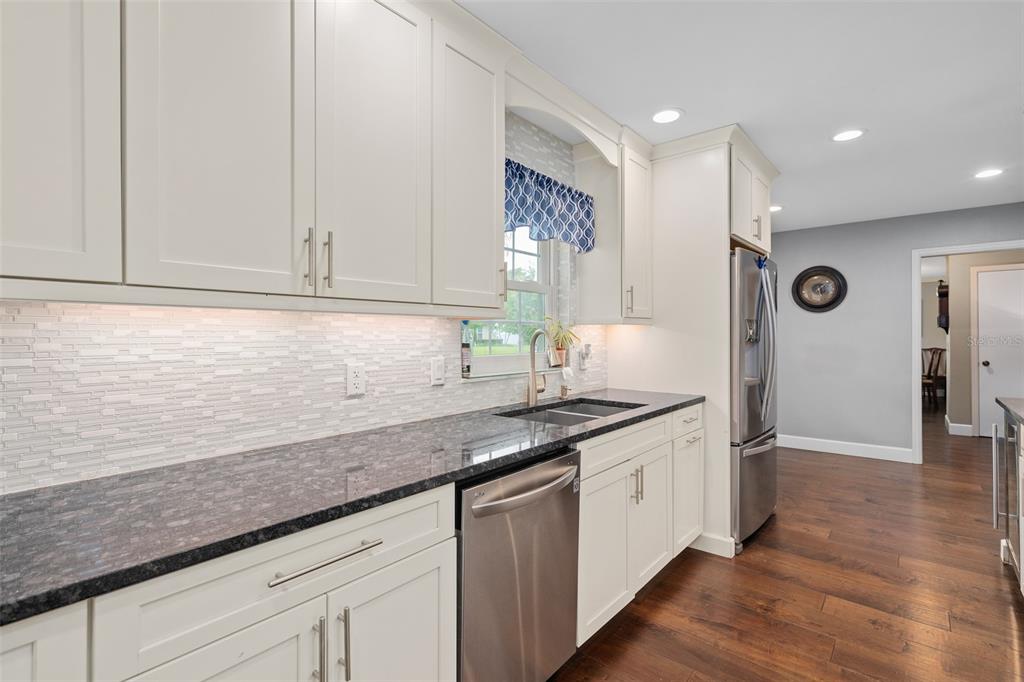 744 Cornwall Road Winter Park, FL 32792 - Photo 6 of 57 a kitchen with stainless steel appliances granite countertop a sink and a white cabinets