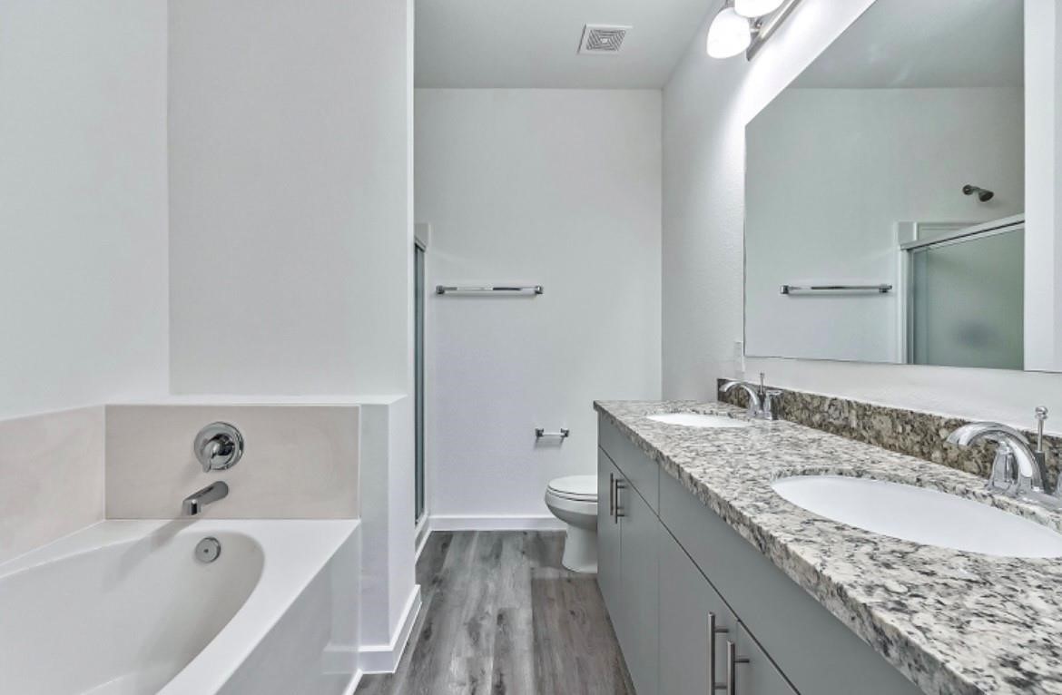 4811 Dig Dug Lane, Unit B Houston, TX 77048 - Photo 9 of 19 a bathroom with a granite countertop sink a toilet and bathtub