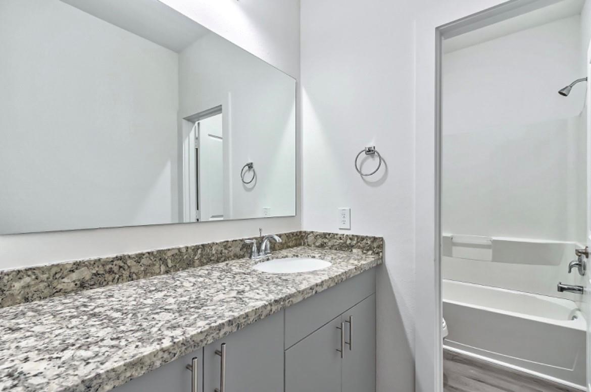 4811 Dig Dug Lane, Unit B Houston, TX 77048 - Photo 10 of 19 a bathroom with a granite countertop sink and a bathtub