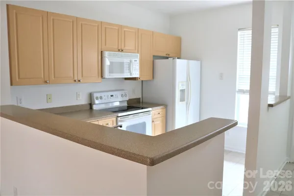 a kitchen with stainless steel appliances granite countertop a refrigerator a stove and a sink with wooden floor