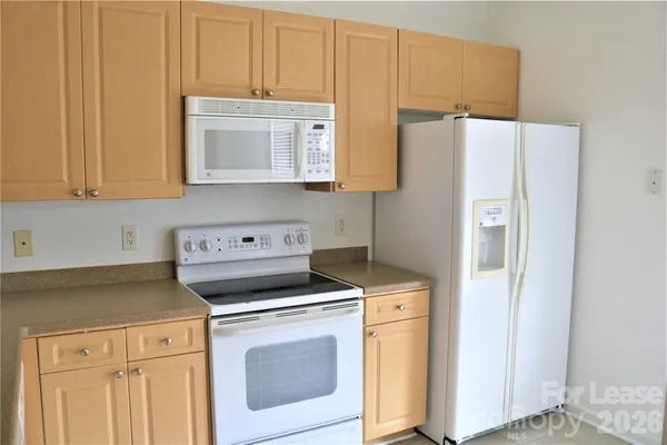 a kitchen with a refrigerator sink stove and cabinets