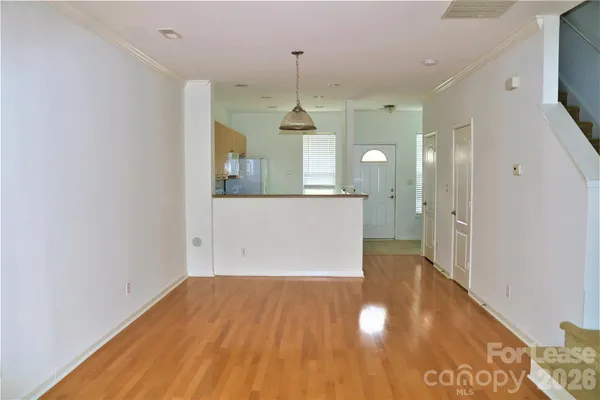 a view of a kitchen with wooden floor and a window