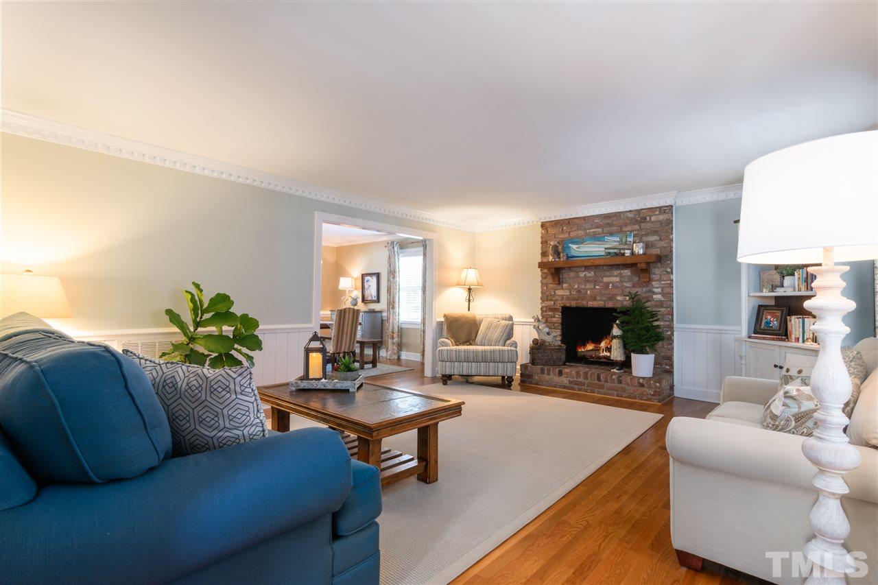 6304 Wynbrook Way Raleigh, NC 27612 - Photo 5 of 30 a living room with furniture a fireplace and a potted plant