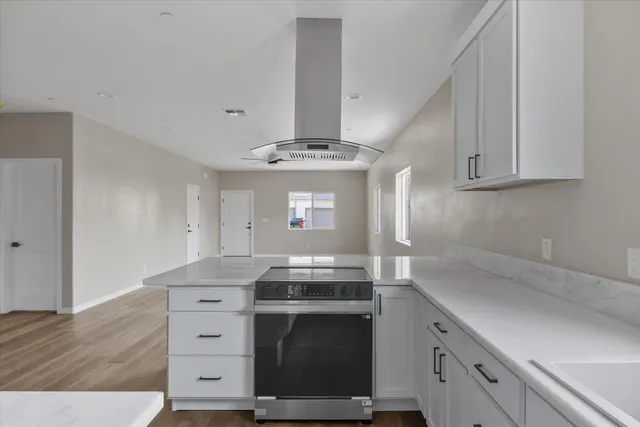 a kitchen with white cabinets and sink