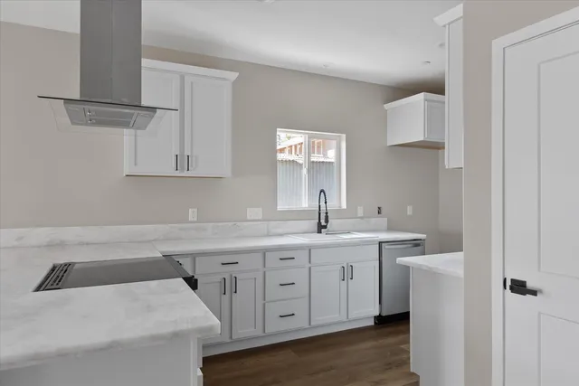a kitchen with granite countertop white cabinets and stainless steel appliances