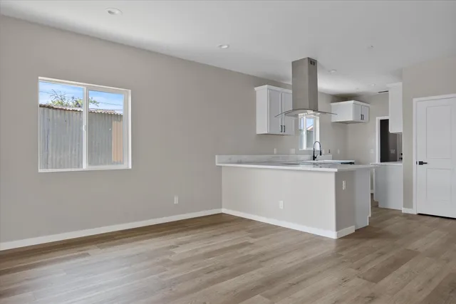 a large white kitchen with a sink and a large mirror