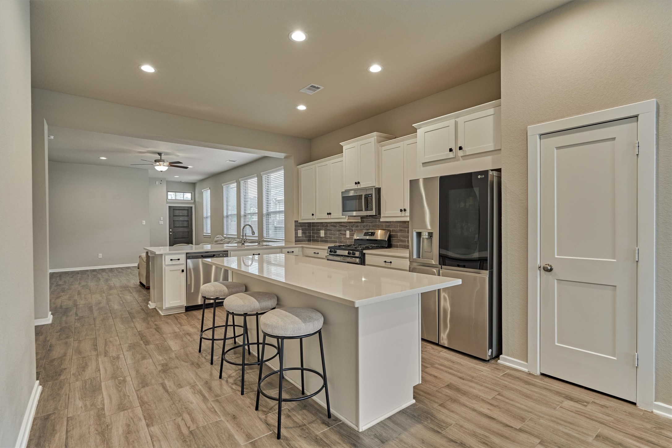 10545 Wild Chives Conroe, TX 77385 - Photo 16 of 34 a kitchen with stainless steel appliances a dining table chairs refrigerator and cabinets