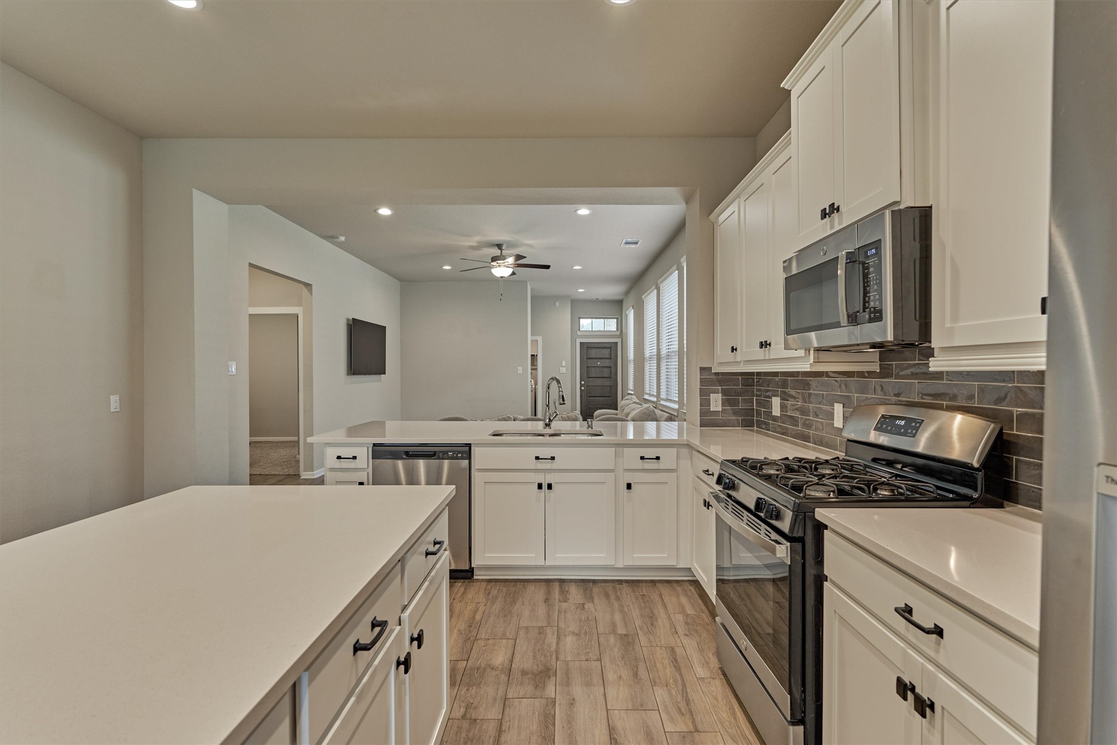 10545 Wild Chives Conroe, TX 77385 - Photo 17 of 34 a kitchen with stainless steel appliances a sink stove and cabinets