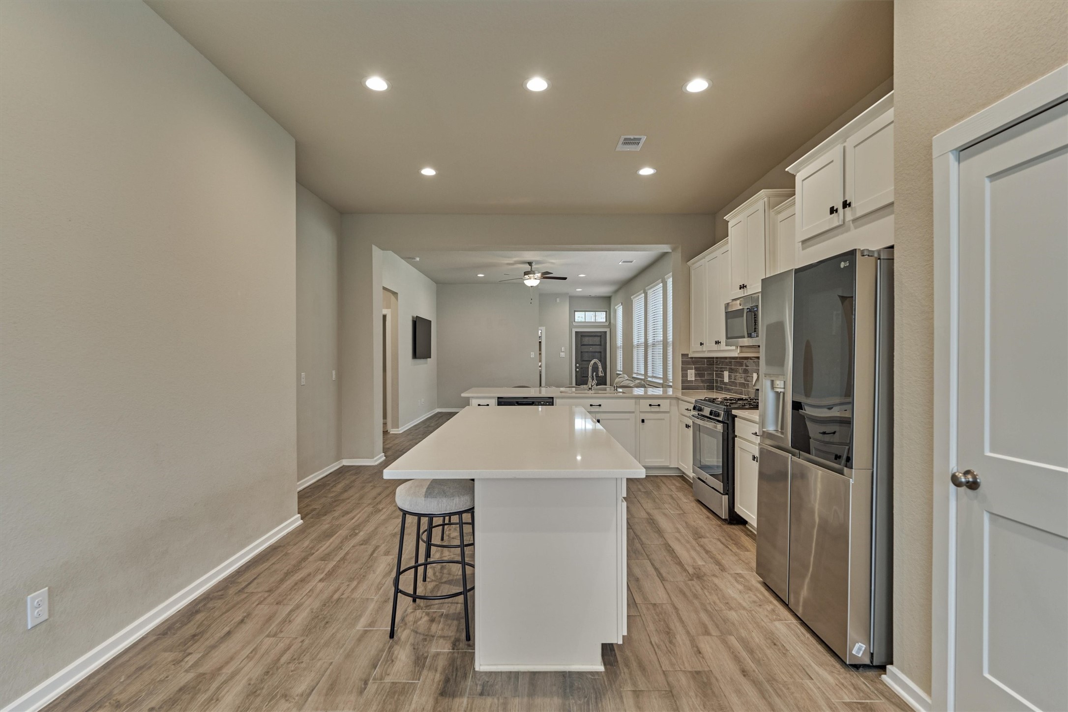 10545 Wild Chives Conroe, TX 77385 - Photo 18 of 34 a large kitchen with a table chairs refrigerator and wooden floor