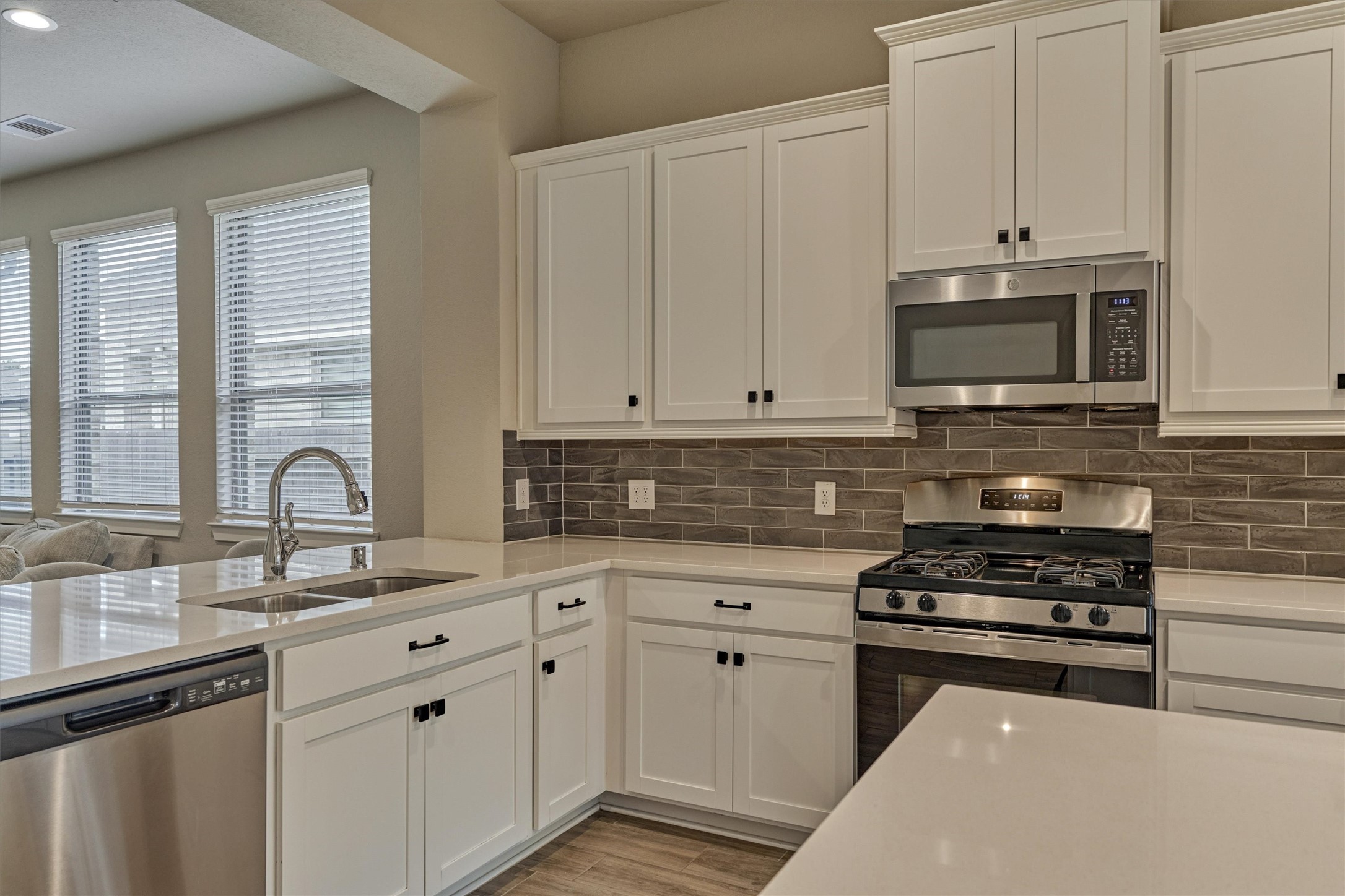 10545 Wild Chives Conroe, TX 77385 - Photo 19 of 34 a kitchen with granite countertop white cabinets and stainless steel appliances
