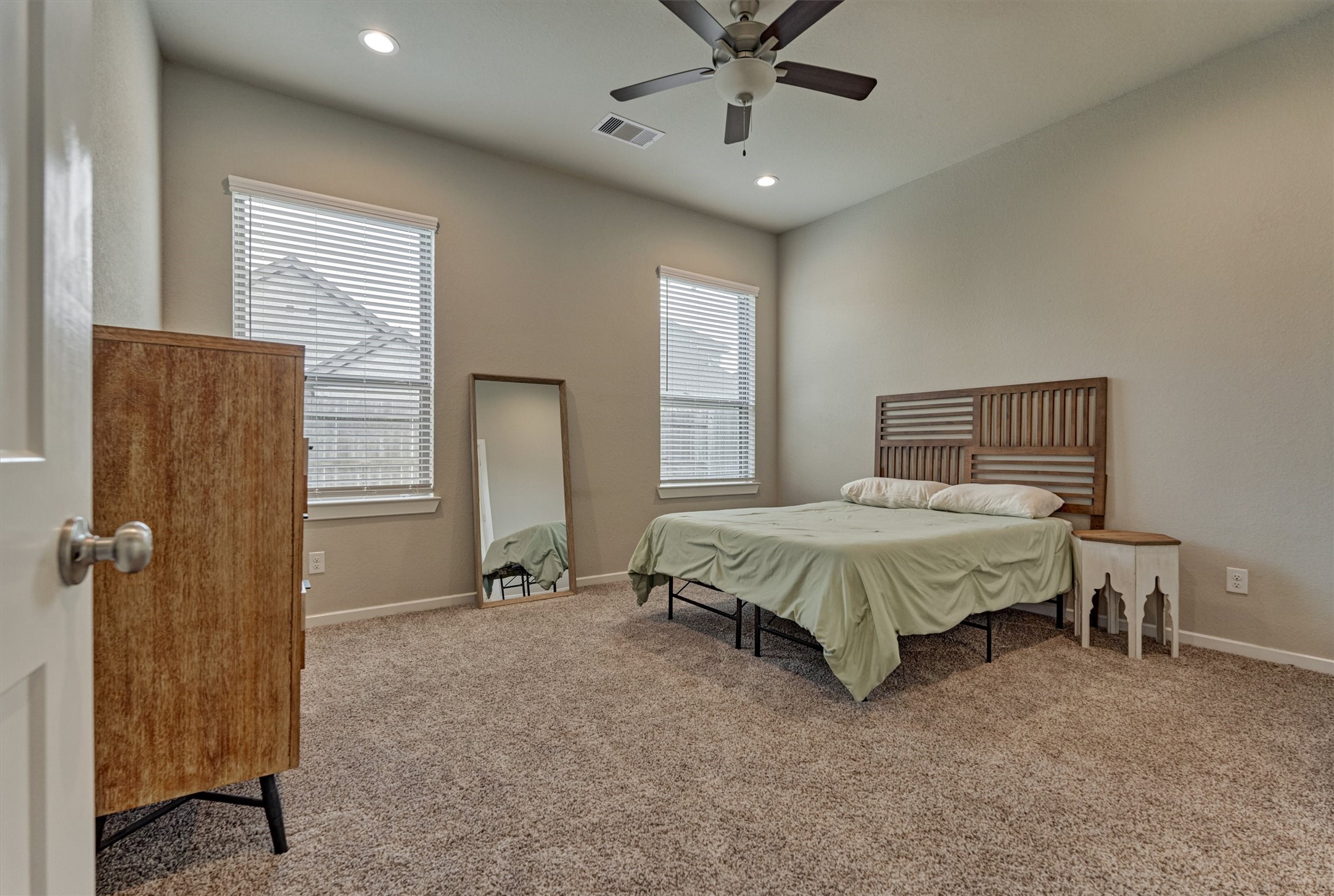 10545 Wild Chives Conroe, TX 77385 - Photo 23 of 34 a spacious bedroom with a bed and a chandelier