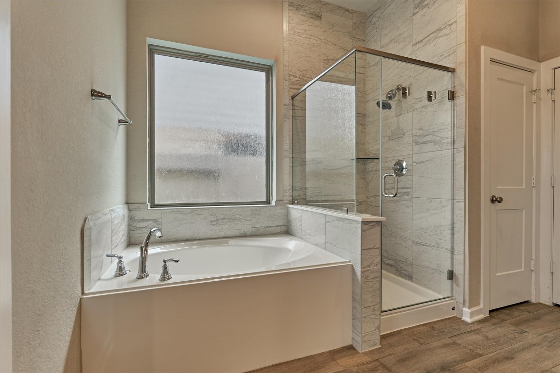 10545 Wild Chives Conroe, TX 77385 - Photo 3 of 34 a bathroom with a tub and a shower