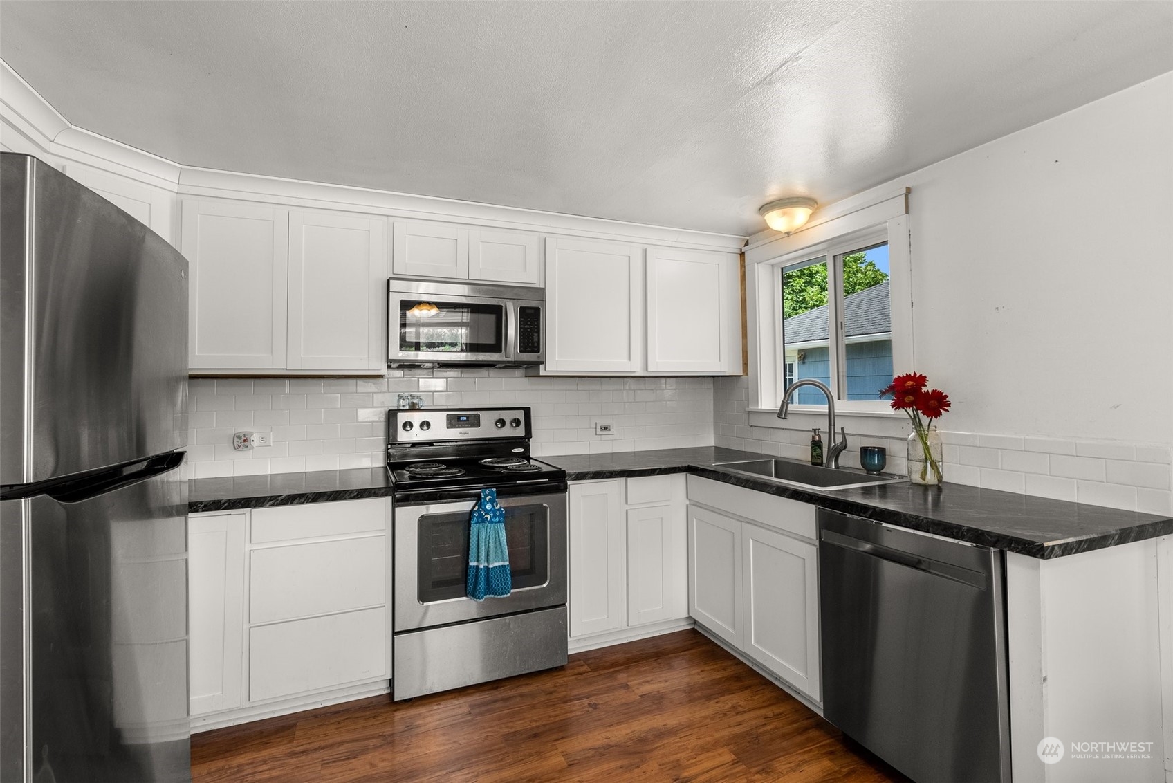 340 Meier Road Winlock, WA 98596 - Photo 11 of 26 a kitchen with stainless steel appliances a sink dishwasher a stove top oven a refrigerator with wooden floor and cabinets