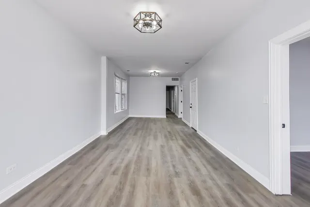 a view of a room with wooden floor and window