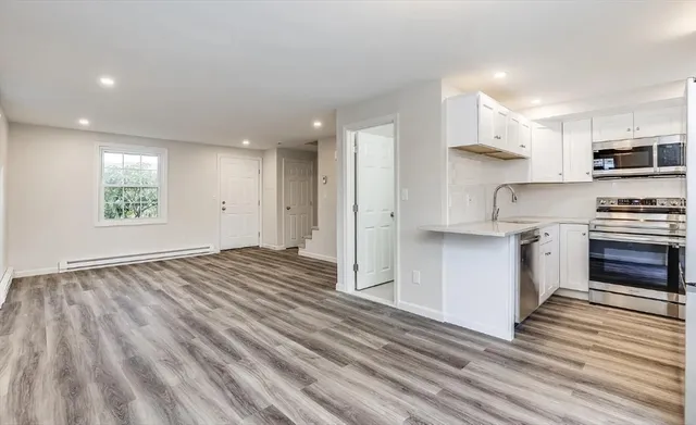 a view of kitchen with wooden floor electronic appliances and window