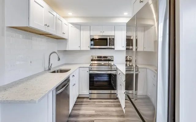 a kitchen with stainless steel appliances granite countertop a sink stove and refrigerator