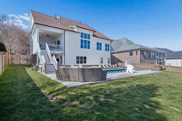 a view of a house with a yard and wooden fence