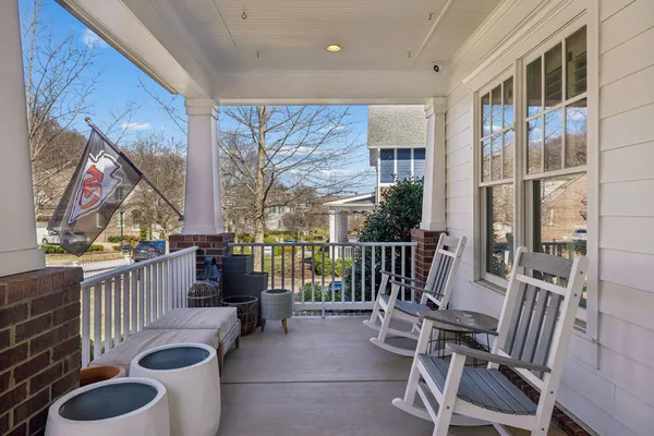 a balcony with chairs and a potted plant