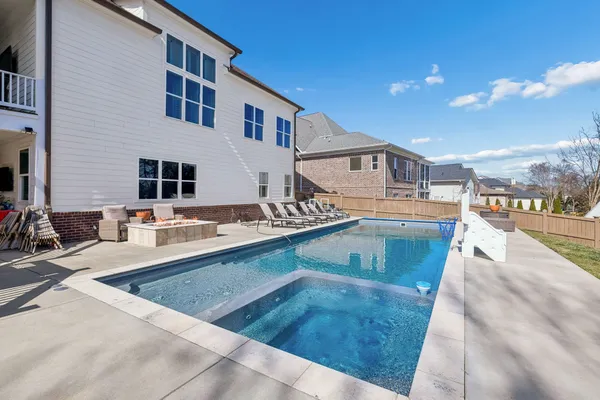 a view of a house with pool and chairs