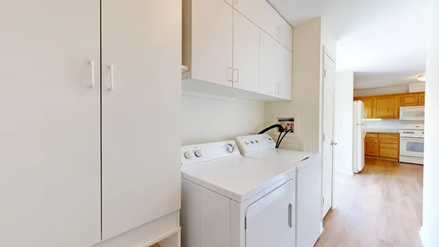 a utility room with cabinets washer and dryer