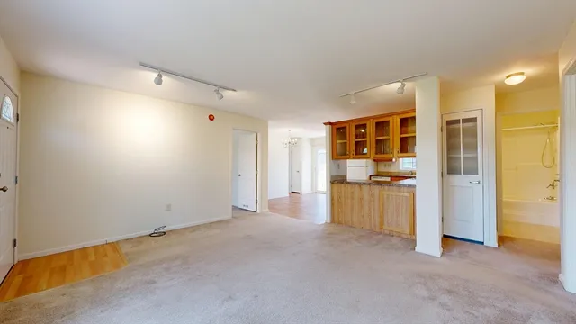 a view of empty room with a kitchen