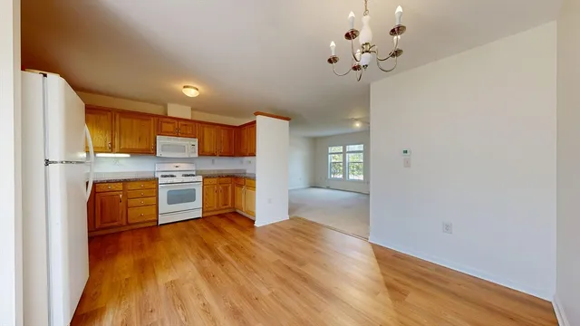 a kitchen with stainless steel appliances a refrigerator a sink dishwasher with a dining table and chairs