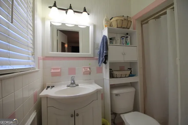 a bathroom with a toilet sink and mirror