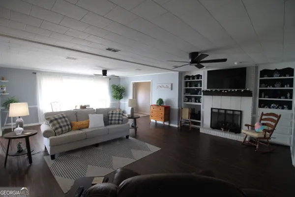 a living room with furniture a fireplace and a flat screen tv