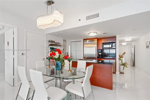 a dining room filled chandelier and wooden floor
