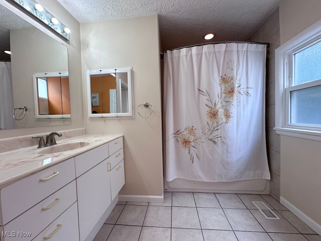 6846 Ottawa Road Cleveland, OH 44105 - Photo 19 of 50 Full bath with visible vents, shower / bathtub combination with curtain, a textured ceiling, tile patterned flooring, and vanity