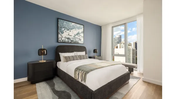 a bedroom with a bed two lamp on desk and a window