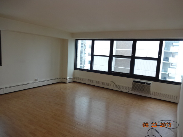 6030 North Sheridan Road, Unit 912 Chicago, IL 60660 - Photo 3 of 7 wooden floor in an empty room with a window