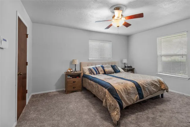 a spacious bedroom with a bed and a chandelier