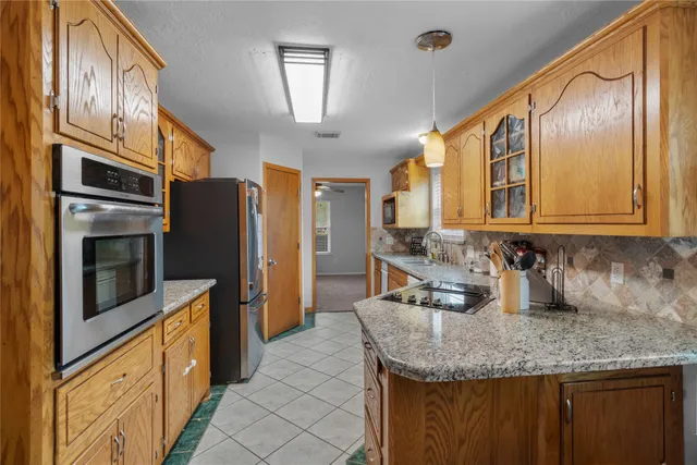 a kitchen with stainless steel appliances granite countertop a sink refrigerator and microwave