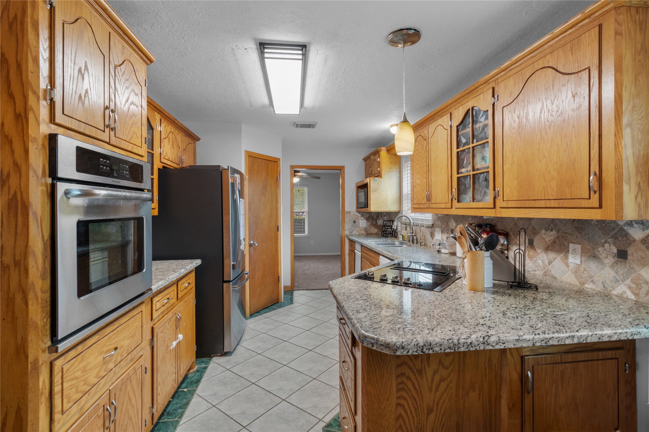 4322 Aztec Street Pasadena, TX 77504 - Photo 9 of 18 a kitchen with stainless steel appliances granite countertop a sink refrigerator and microwave