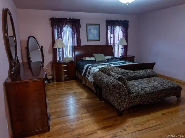 a bedroom with bed and wooden floor