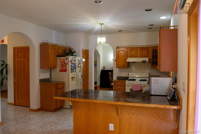 a kitchen with stainless steel appliances granite countertop a refrigerator and a stove