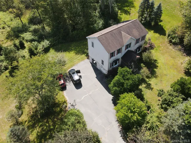 an aerial view of a house with yard and lake view
