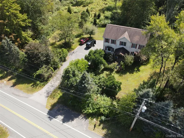 an aerial view of house with yard and mountain view in back