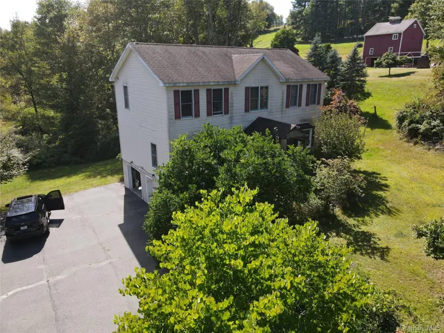 a aerial view of a house with swimming pool next to a yard
