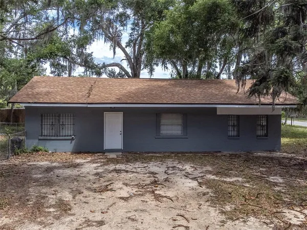 a front view of a house with a tree