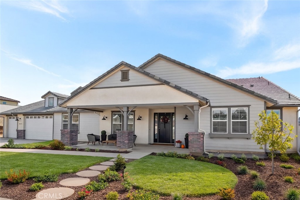 a front view of a house with a yard outdoor seating and garage