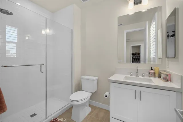 a bathroom with a toilet a sink a mirror and shower