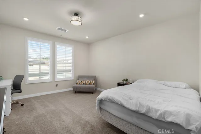 a spacious bedroom with a bed and a couch