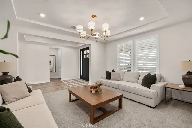 a living room with furniture potted plant and a chandelier